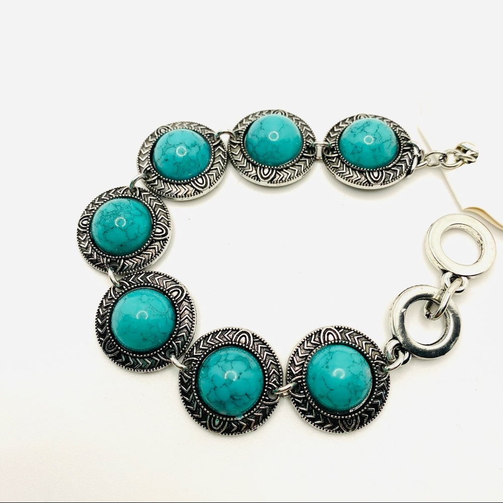 Bracelet Turquoise color and set in silver tone.